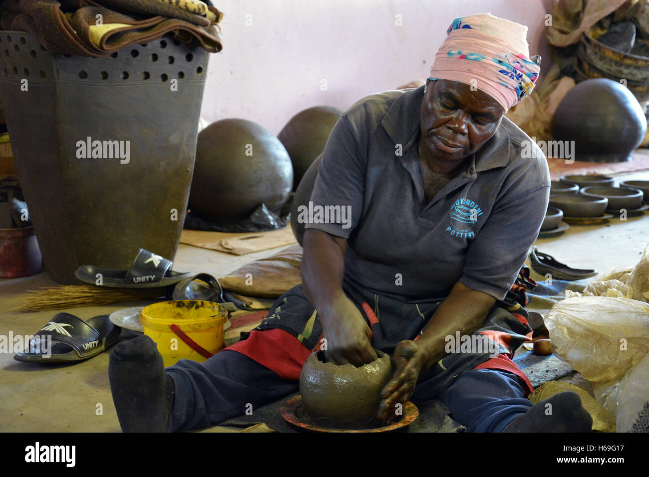 Una donna dimostra come ella crea le pentole di creta in vendita presso la Ceramica Mukondeni nella regione di Limpopo del Sud Africa. Foto Stock