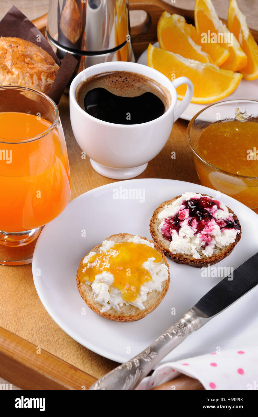 La prima colazione di bun con ricotta arancione e confettura di ciliegie Foto Stock