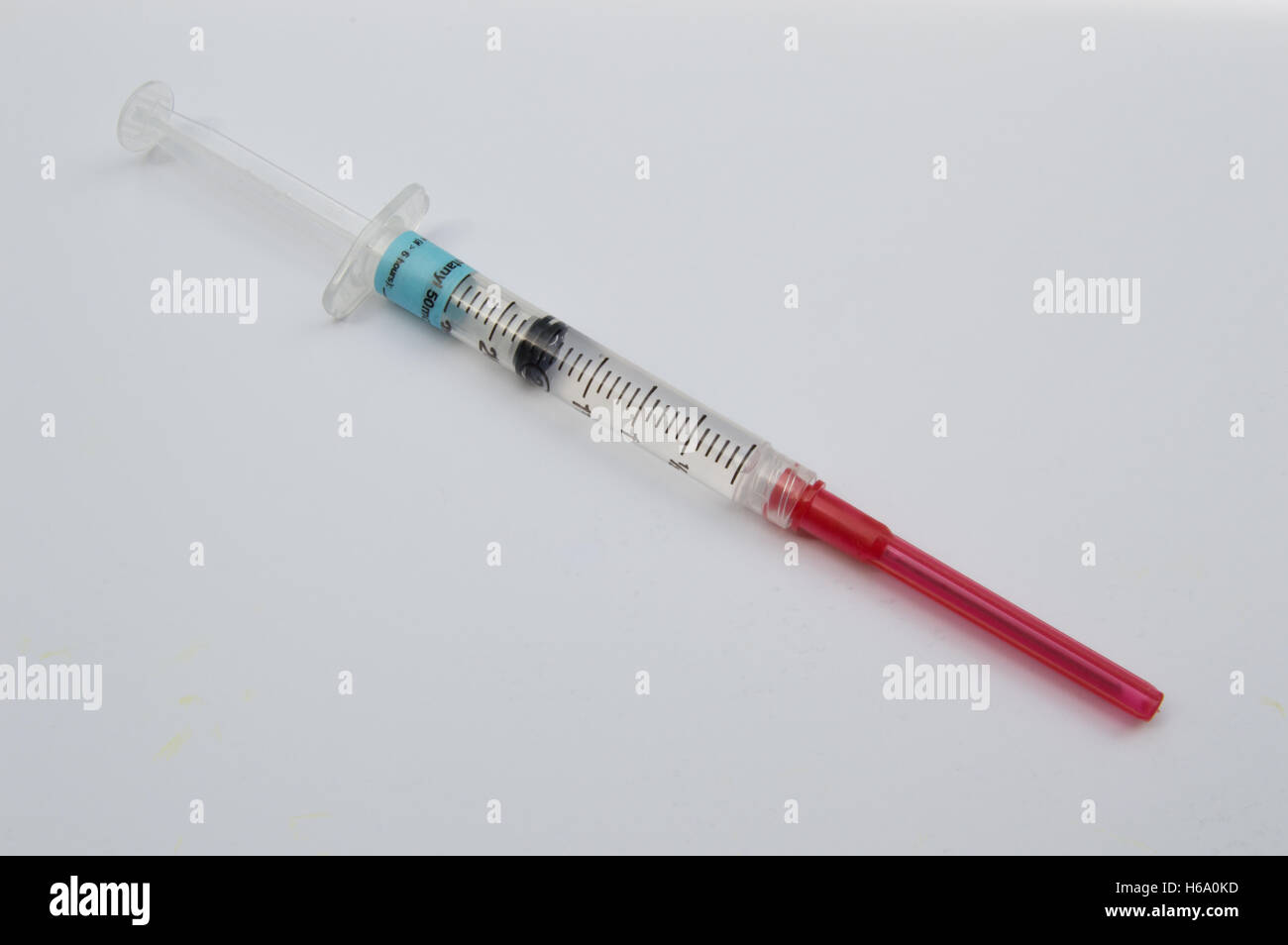 Close up della singola siringa con stupefacenti medicina dolore su sfondo bianco Foto Stock