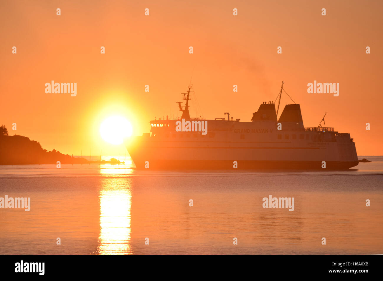 Il ferry boat Grand Manan V si allontana con il sole che sorge dietro di esso. Foto Stock