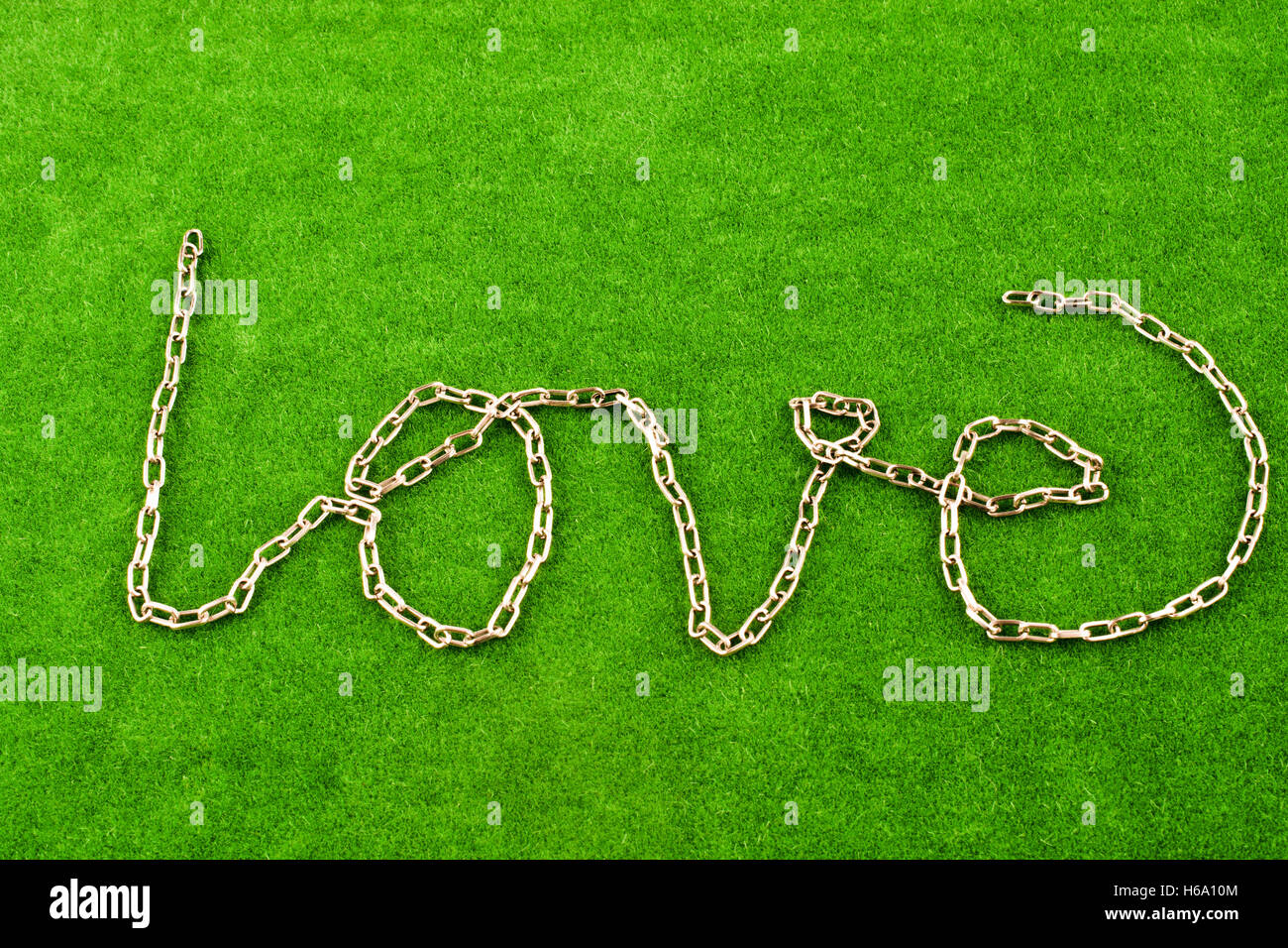 Forma di catena la parola amore su sfondo di erba Foto Stock