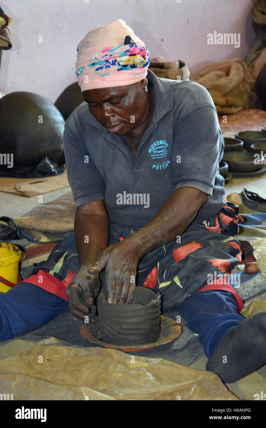 Una donna dimostra come ella crea le pentole di creta in vendita presso la Ceramica Mukondeni nella regione di Limpopo del Sud Africa. Foto Stock