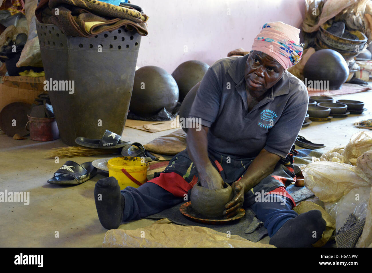 Una donna dimostra come ella crea le pentole di creta in vendita presso la Ceramica Mukondeni nella regione di Limpopo del Sud Africa. Foto Stock