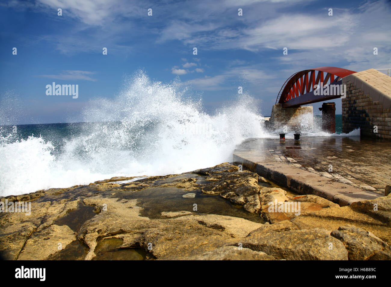 Le onde si infrangono sulla scogliera appena al di fuori del Grand Harbour di Malta Foto Stock