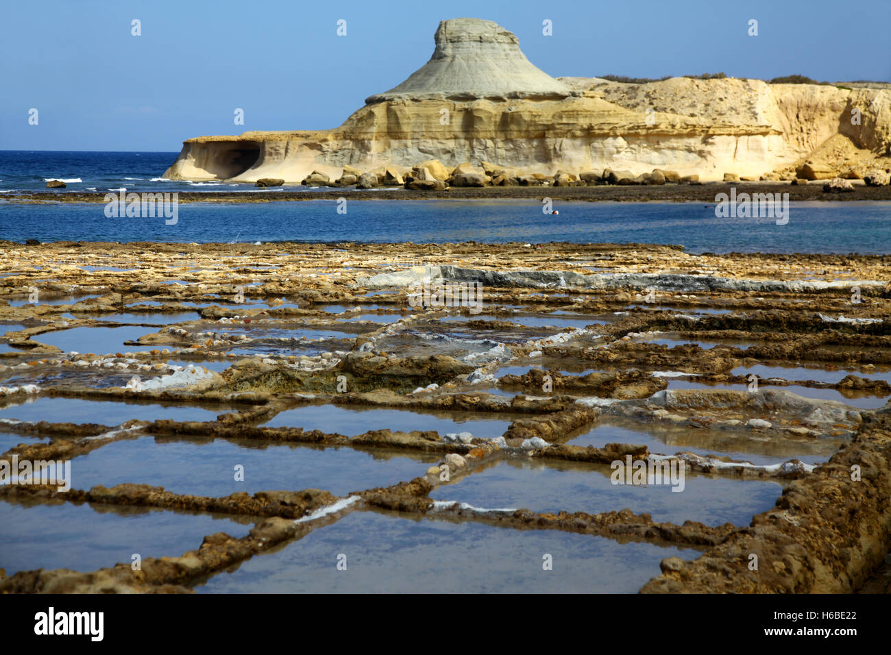Una tranquilla balneazione resort costiero di Gozo con saline in primo piano Foto Stock