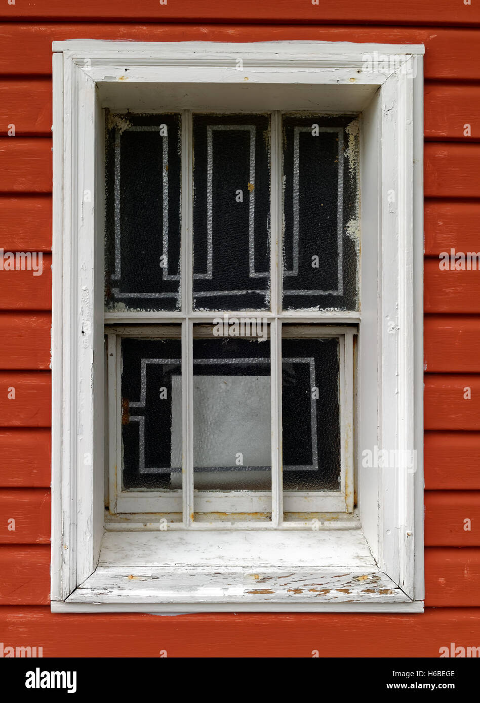 Peeling fatiscente finestra contro brown clapboard parete. Foto Stock