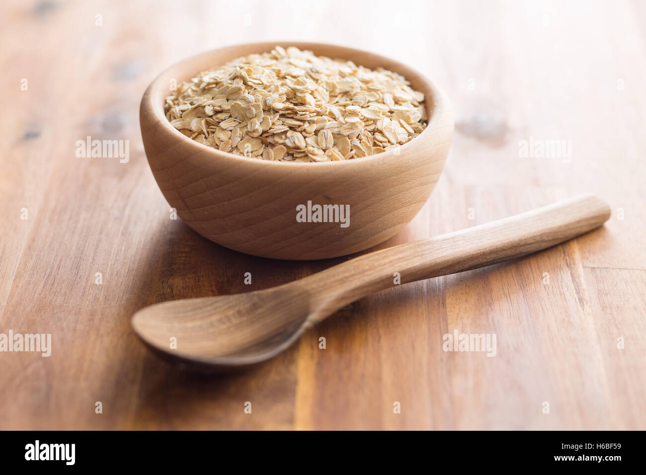 A secco di fiocchi d'avena e laminati in ciotola di legno. Foto Stock