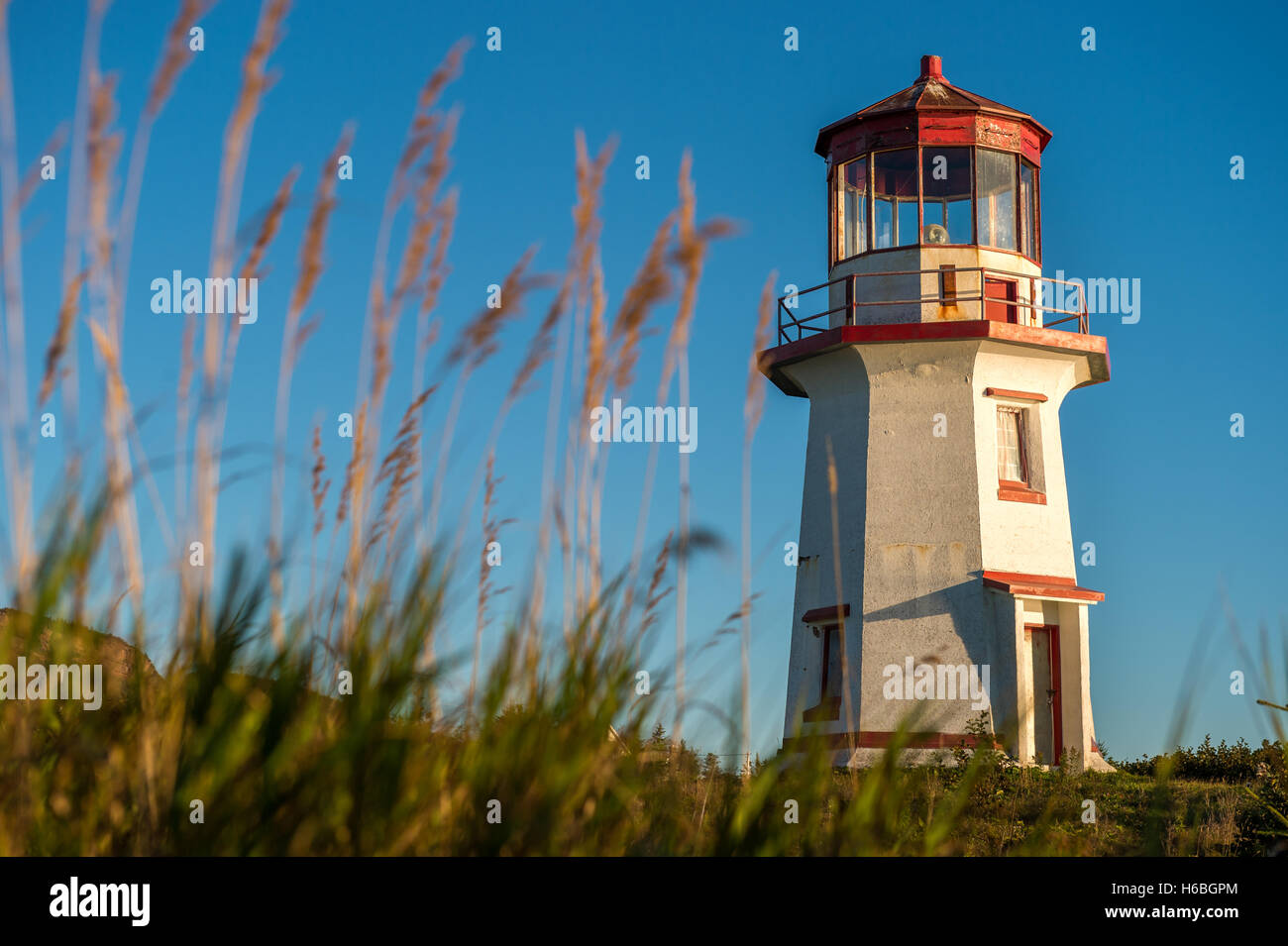 Il bianco e il rosso antico faro oltre il cielo blu in Gaspesie, Quebec (Percé). Foto Stock