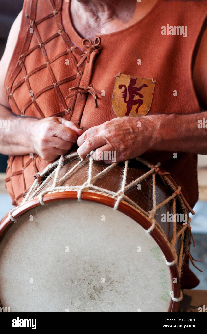 L'Italia, Lombardia, Rievocazione Medievale, uomo regola un tamburo Foto Stock