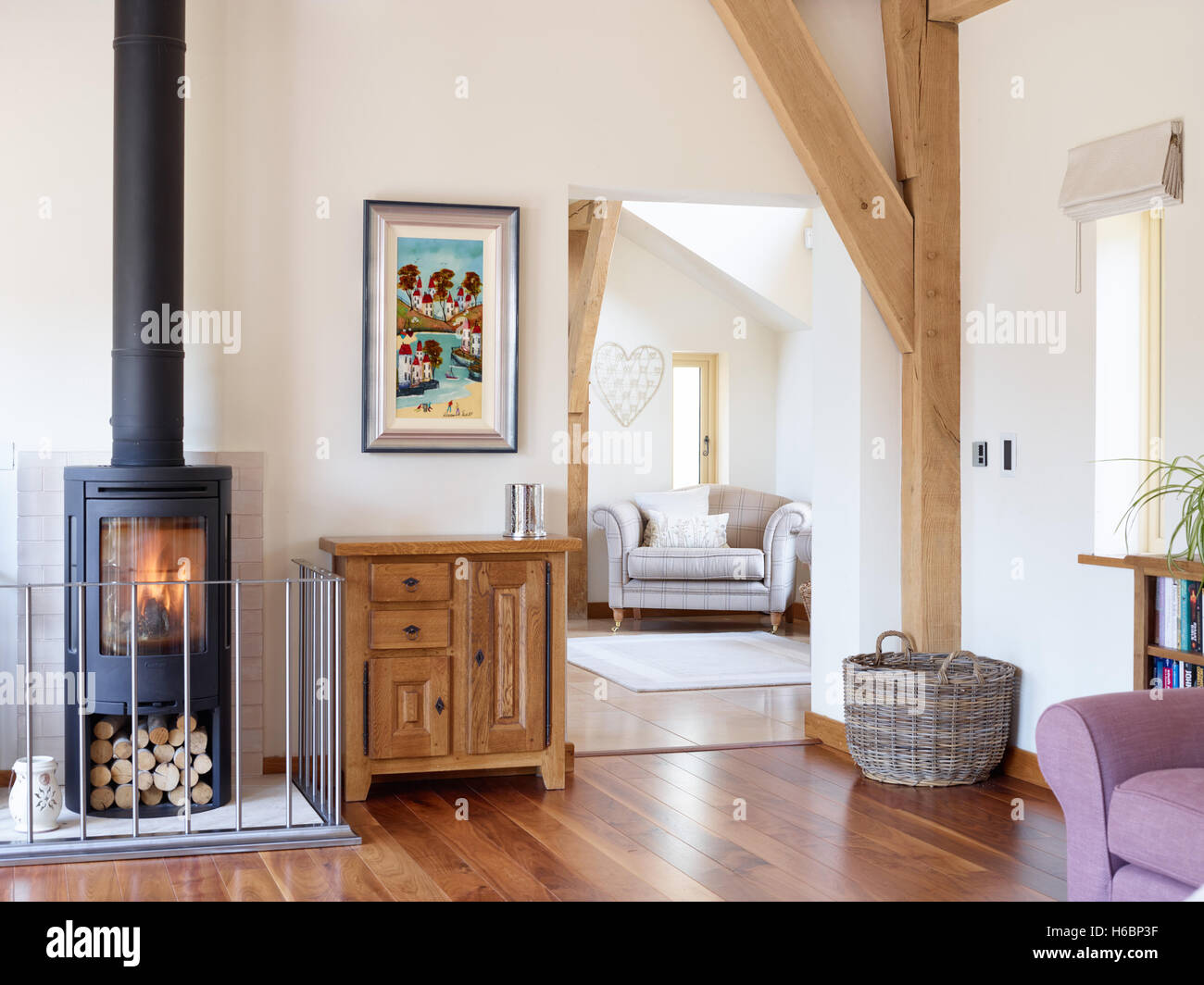 Un confortevole e spazioso soggiorno con solidi pavimenti in legno e di un bruciatore di legno in una considerevole del Regno Unito home. Foto Stock
