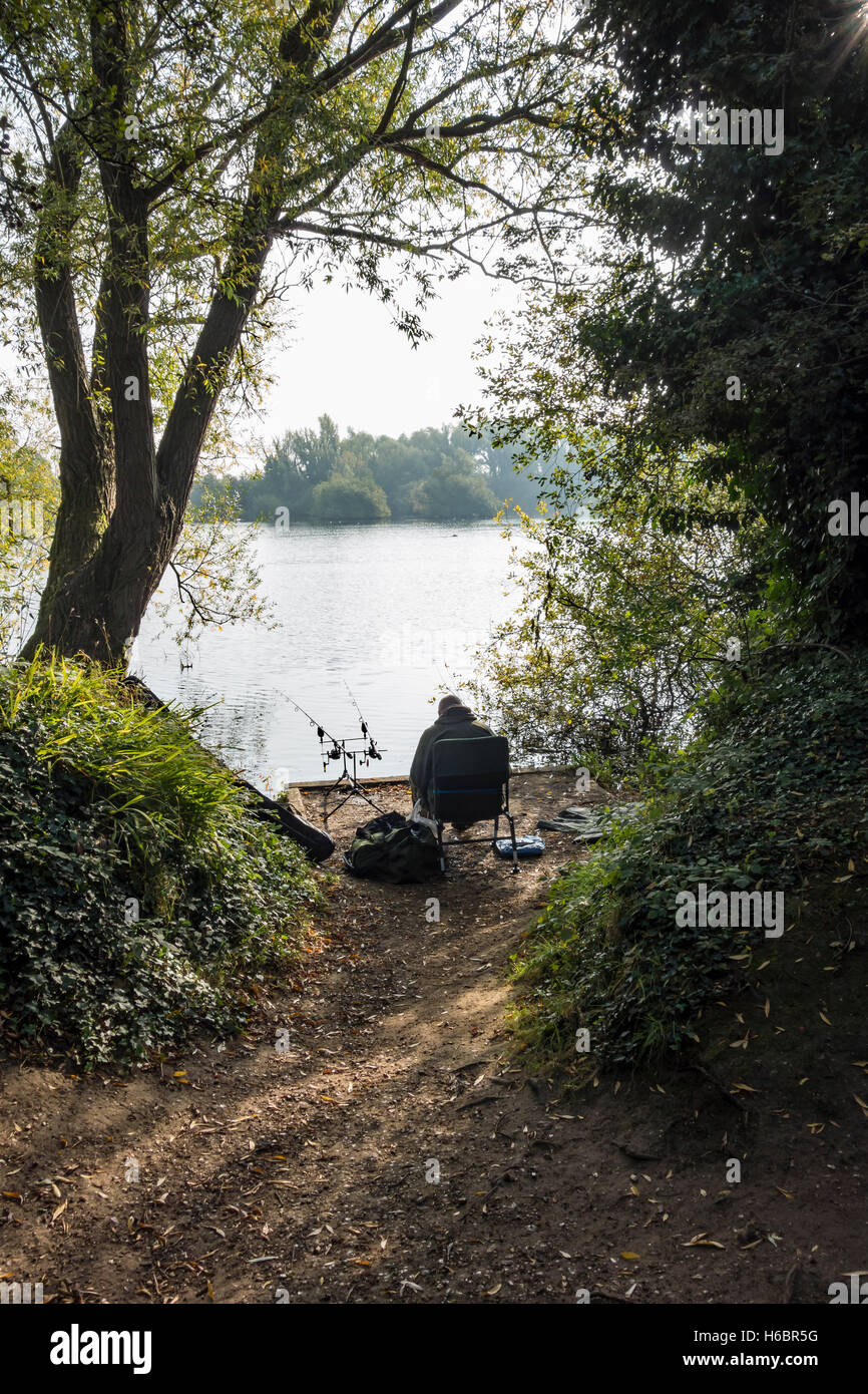 Pescatore del lago per la pesca sportiva con due aste Milton country park Cambridge Cambridgeshire England 2016 Foto Stock