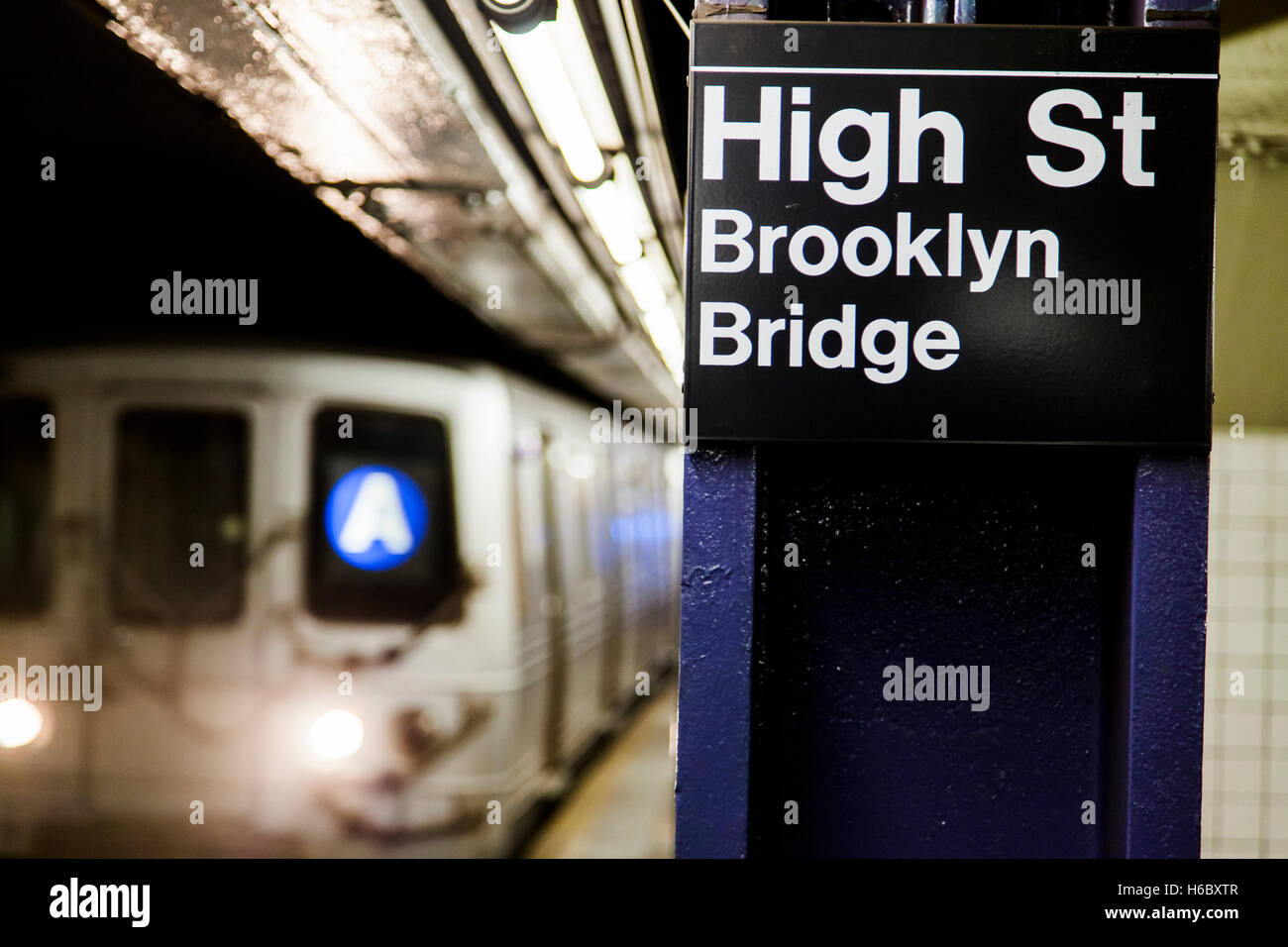 Treno della metropolitana avvicinando dietro il segno raffigurante è il San Brooklyn Stazione del Ponte di Brooklyn, New York. Foto Stock