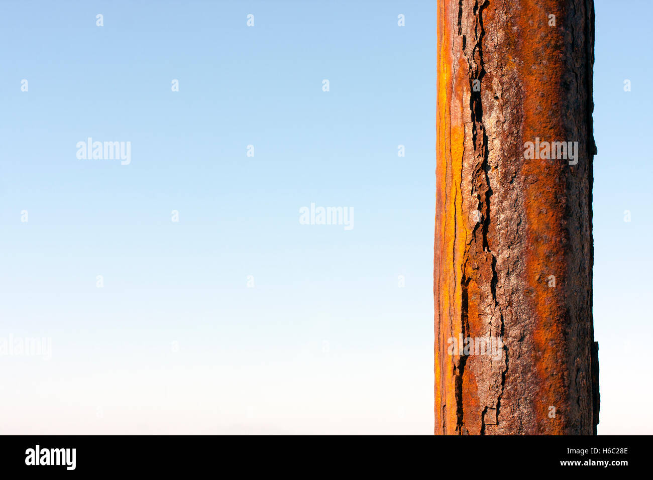 Di ferro arrugginito Pole contro un cielo blu Foto Stock