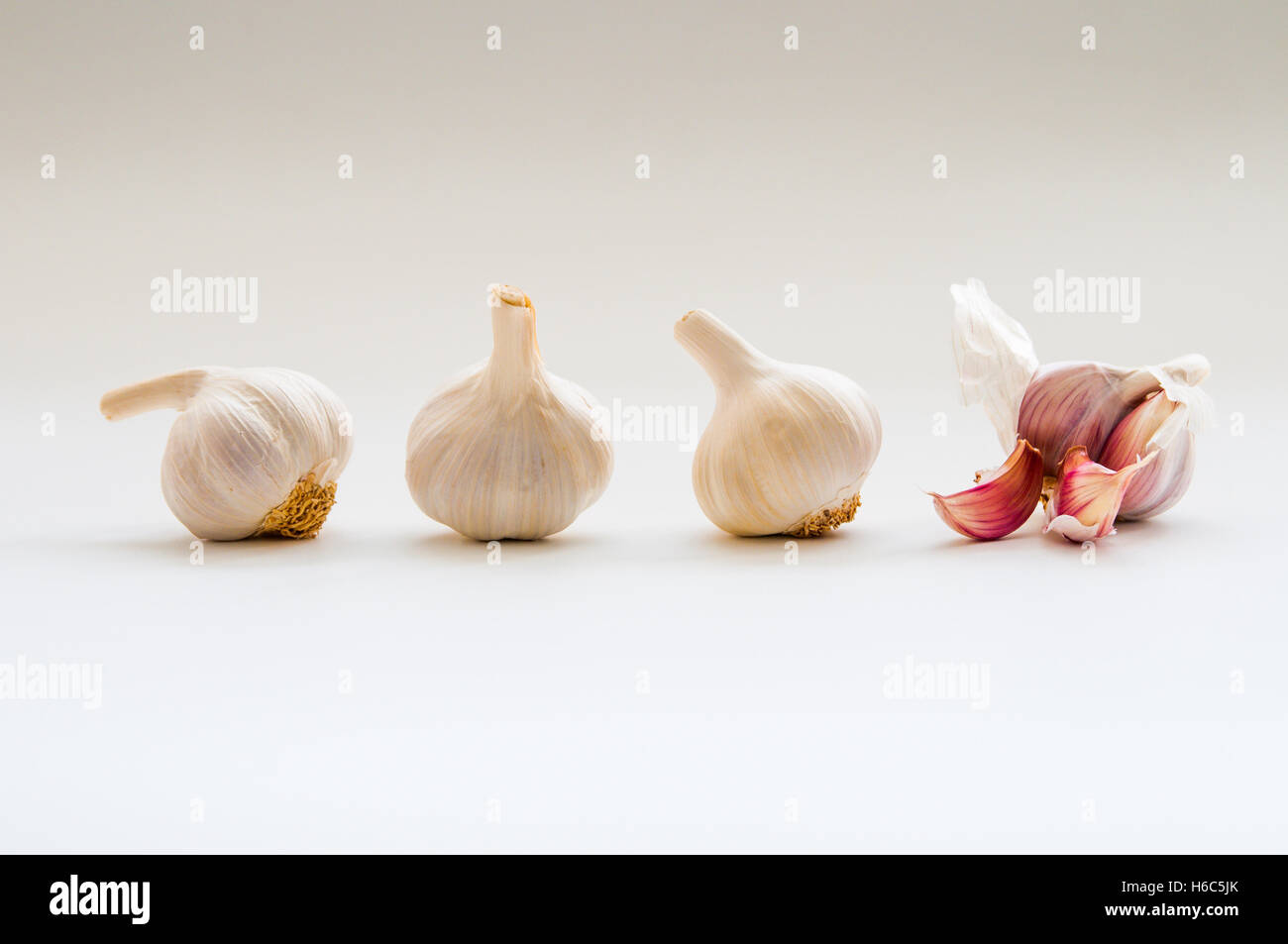 4 bulbi di aglio 1 aperto in una riga Foto Stock