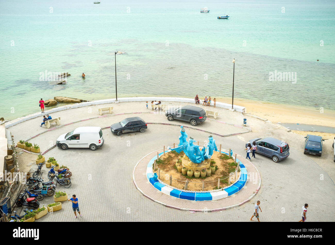 La strada circolare accanto alla spiaggia con le sirene sculture in medio Foto Stock