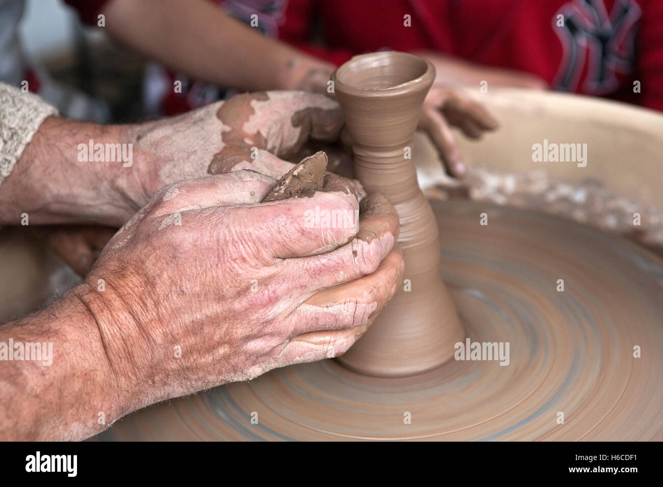 Master plasmare un pezzo di ceramica sul tornio del vasaio Foto Stock