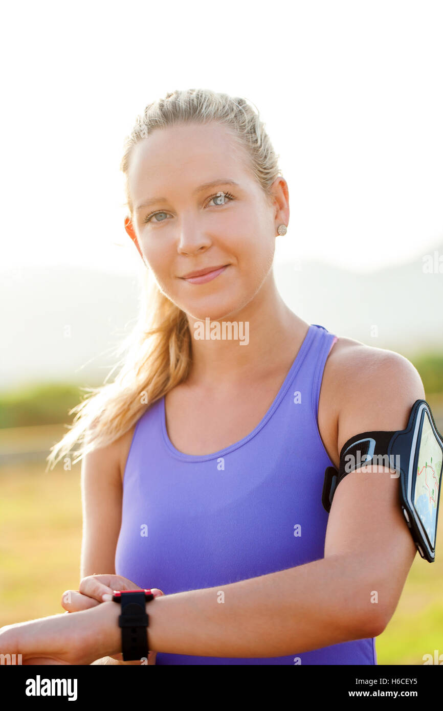 Close up ritratto di attraente giovane donna indossa smart watch e smart watch bracciale. Giovane atleta nello sport usura. Foto Stock