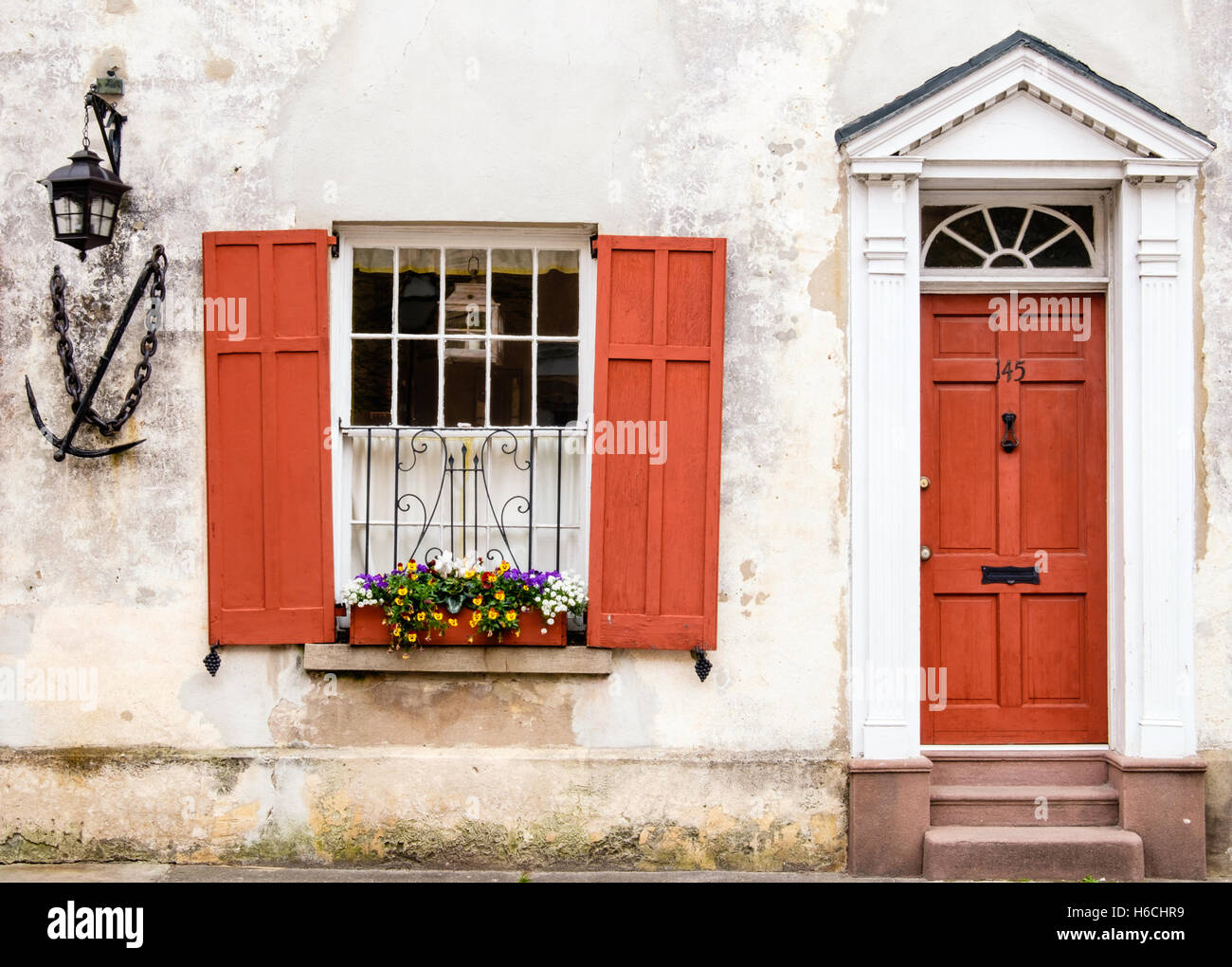Scenario incantevole di una finestra decorata con fiori e struttura in legno porta nel quartiere storico di Charleston, Carolina del Sud Foto Stock
