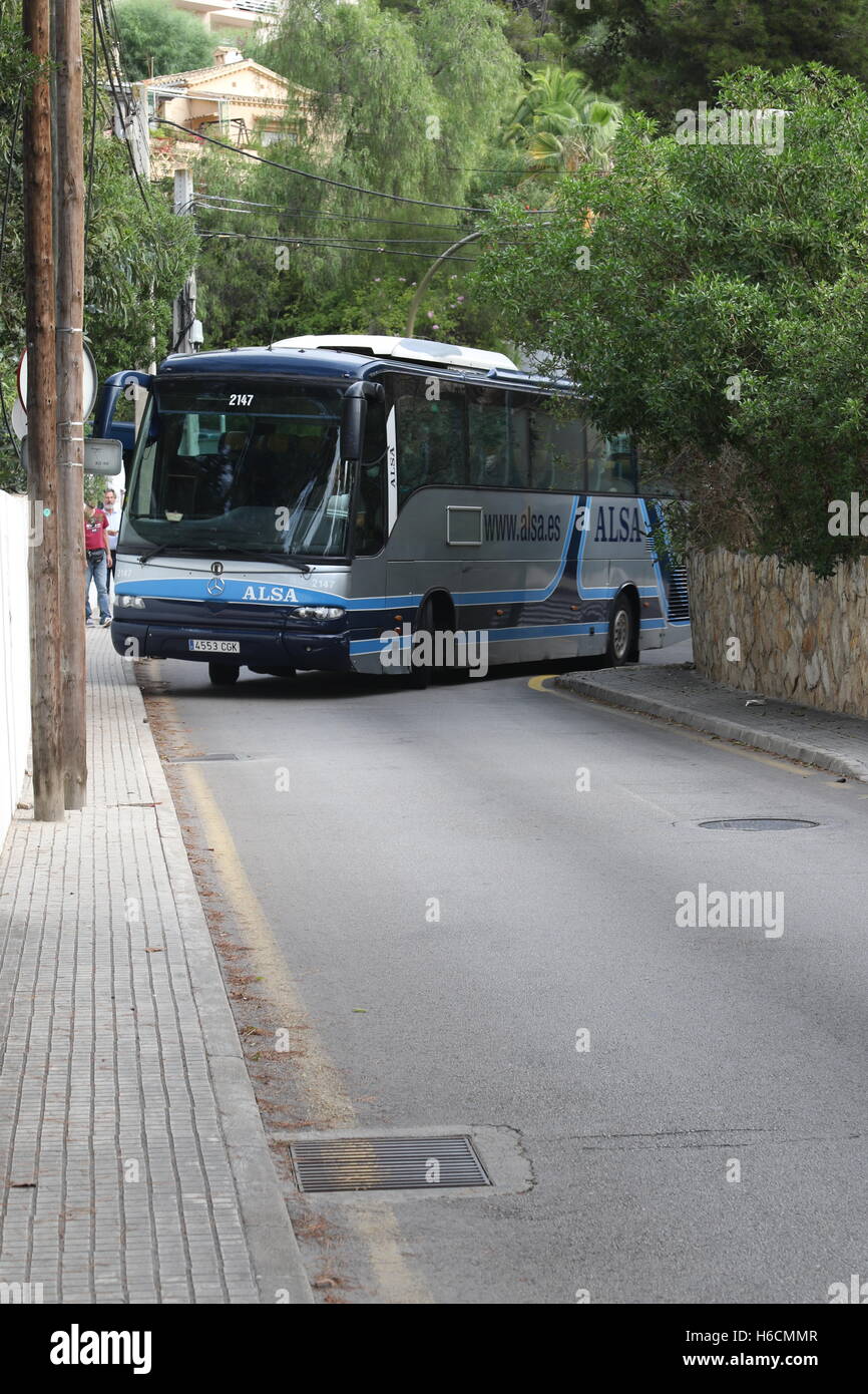 Un tour vacanza coach negozia un molto stretto incrocio stradale. Foto Stock