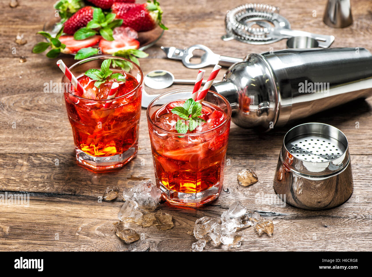 Red drink con ghiaccio. Aperitivo, mojito, caipirinha, succo. Cocktail bar rendendo gli strumenti, fragola e foglie di menta Foto Stock