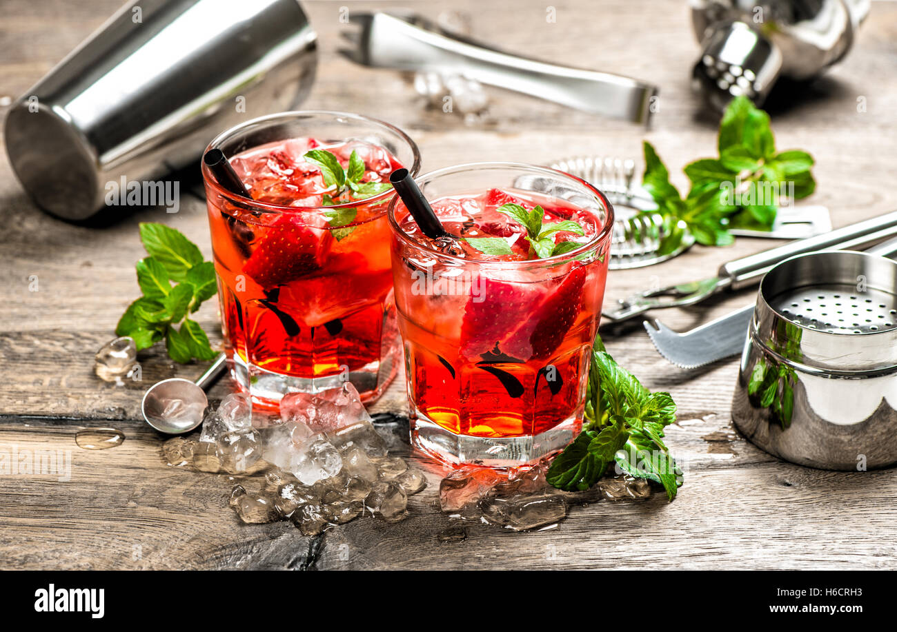 Red drink con Fragola, foglie di menta, ghiaccio. Fare Cocktail bar accessori Foto Stock