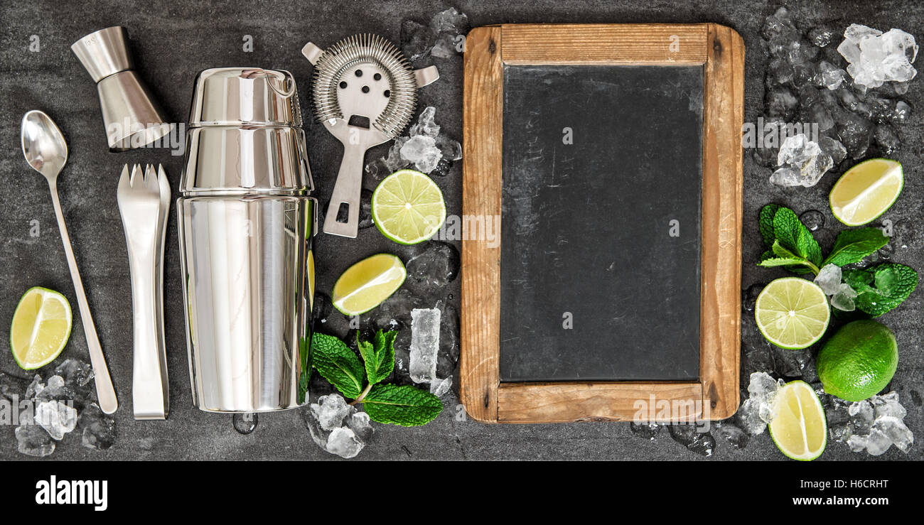 Bere la produzione di attrezzi e gli ingredienti per un cocktail. Lime e foglie di menta. Blackboard per testo ricetta Foto Stock