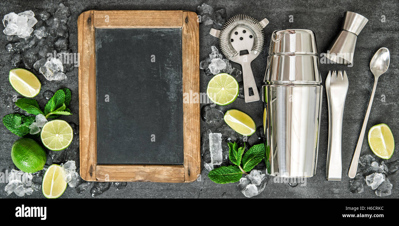 Bere la produzione di attrezzi e gli ingredienti per un cocktail. Lime e foglie di menta. Blackboard per testo ricetta Foto Stock