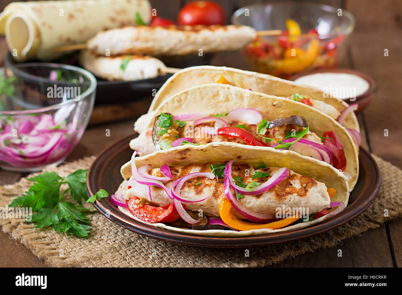Tacos messicano con pollo e verdure grigliate e cipolla rossa. Foto Stock
