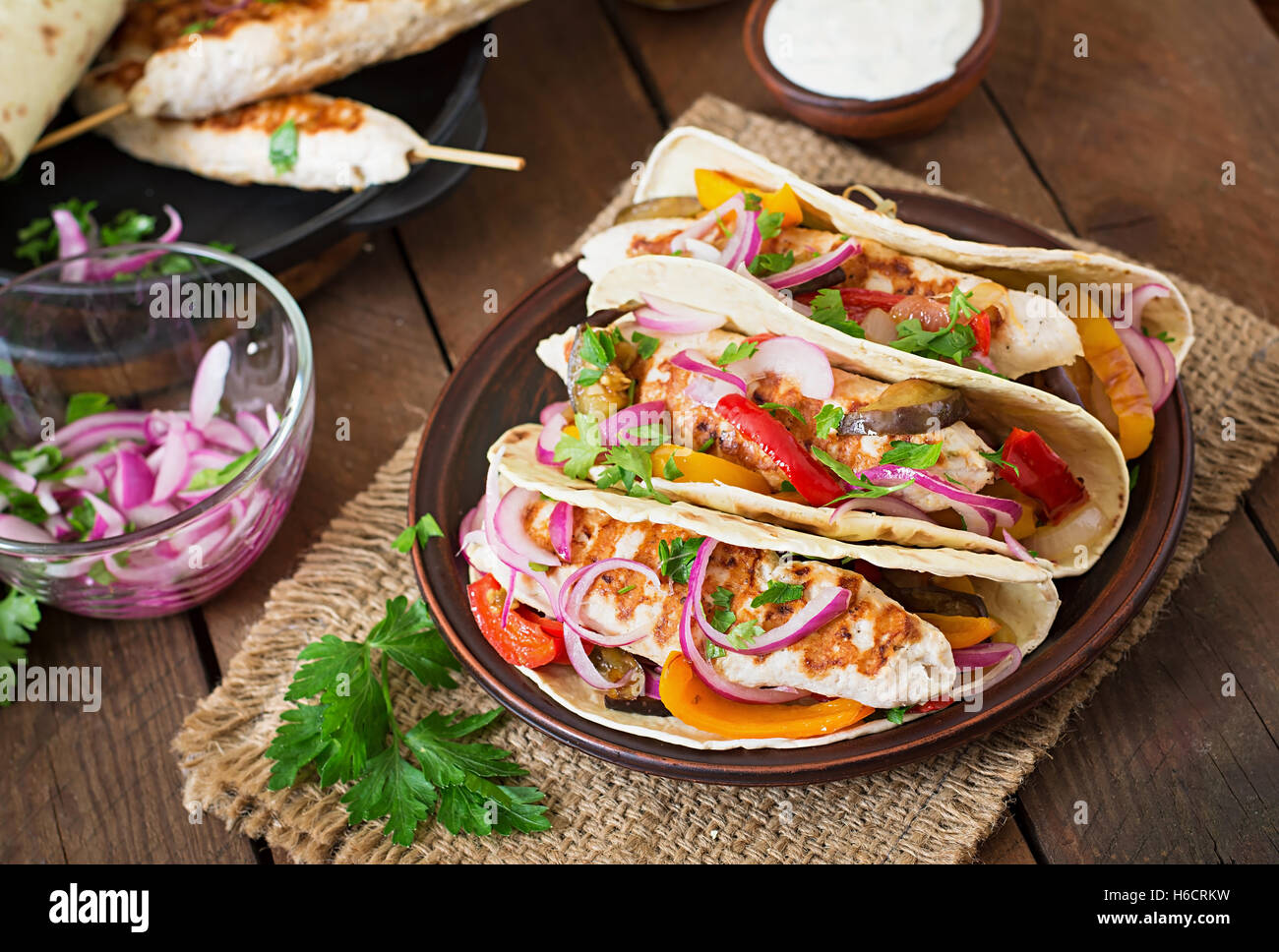 Tacos messicano con pollo e verdure grigliate e cipolla rossa. Foto Stock