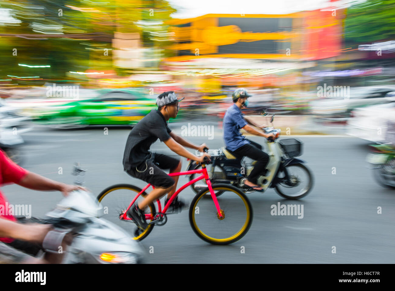 I ciclisti e gli scooter in condizioni di traffico intenso, motion blur, Ho Chi Minh City, Vietnam Foto Stock