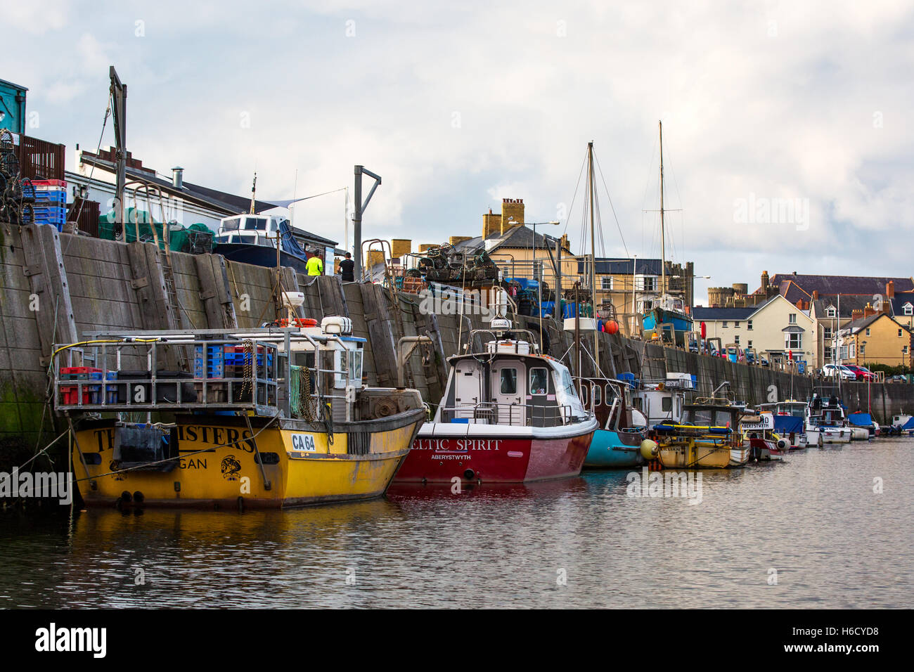 Barche da pesca ormeggiate lungo Aberystwyth Harbour wall Foto Stock