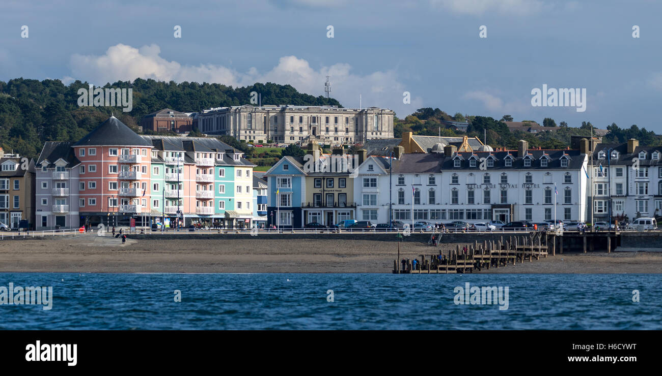 Una vista di Aberystwyth proprietà lungo il lungomare, guardando dal mare con la biblioteca nazionale del Galles in background Foto Stock