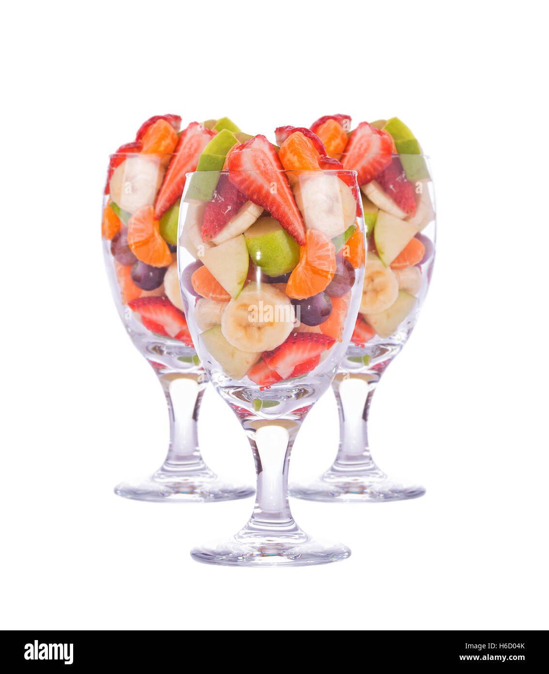 Tre colorate, salutari insalate di frutta in grandi bicchieri, isolato su bianco Foto Stock