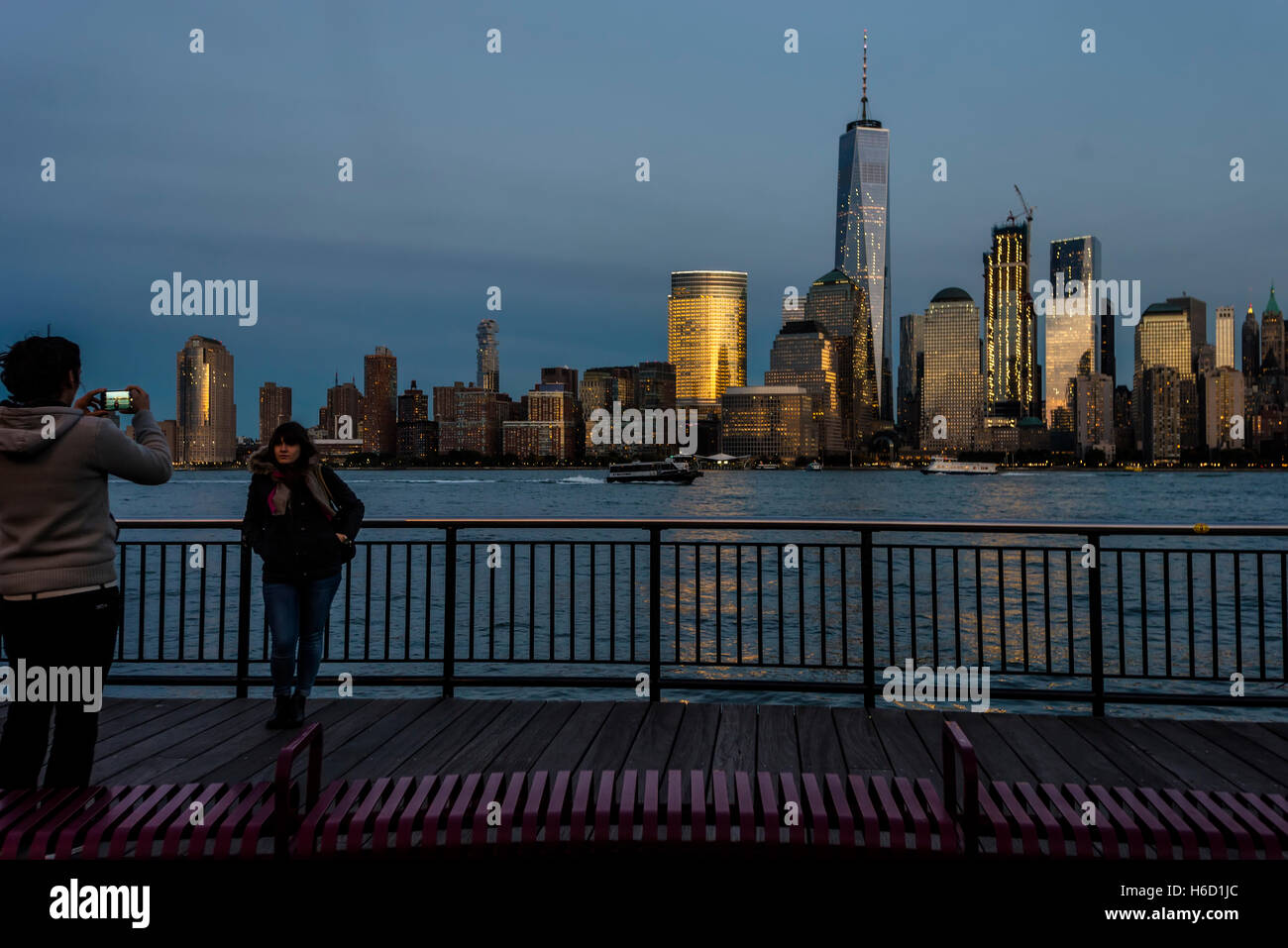 Jersey City, NJ 26 ottobre 2016 = persone di scattare una istantanea sul Jersey City lungomare con una vista della parte inferiore della Skyline di Manhattan con il World Trade Center e il Centro Finanziario Mondiale in background. Foto Stock