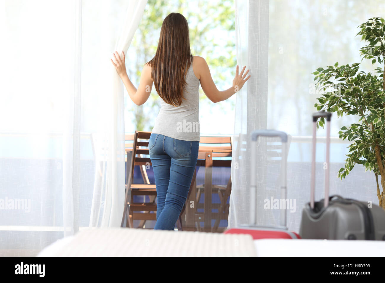 Hotel il cliente nella sua stanza in vacanza guardando al di fuori attraverso la finestra Foto Stock