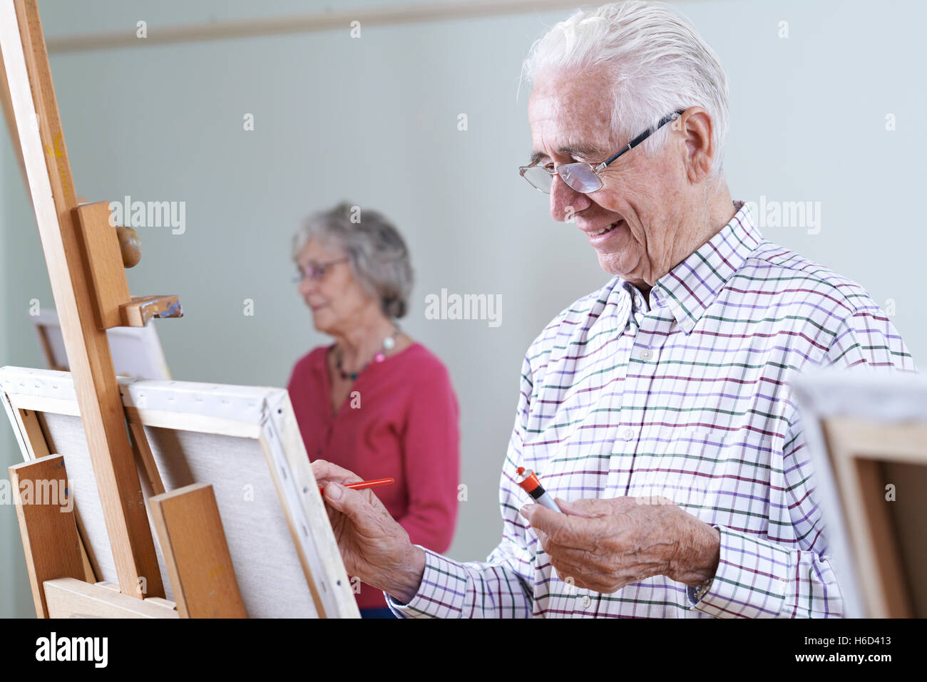 Gli anziani che frequentano la classe di pittura insieme Foto Stock