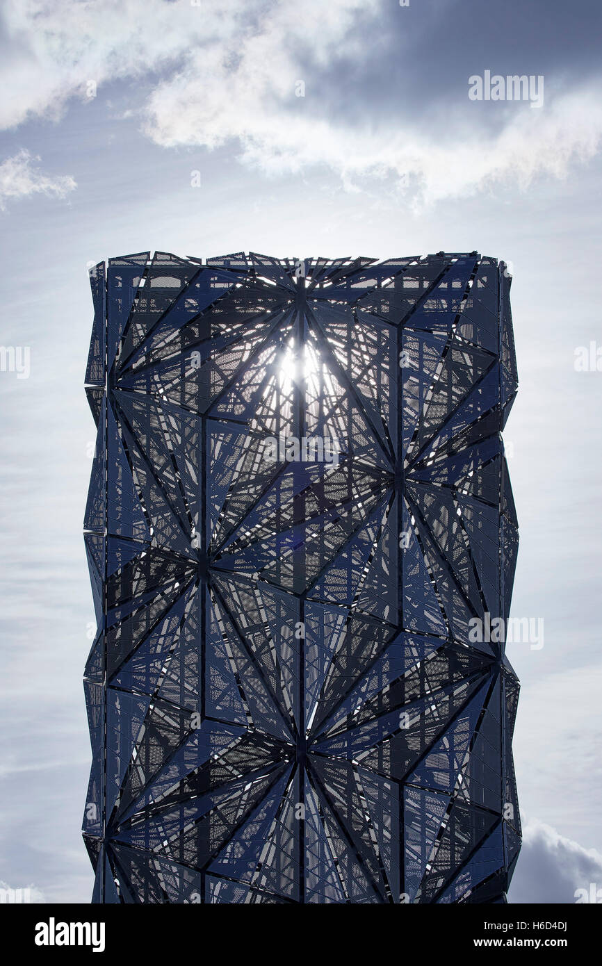 Vista in lontananza scultorei di canna fumaria. Con sfaccettato pannelli forati e il sole che splende attraverso. Greenwich Energy Center / il manto ottica, Greenwich, Regno Unito. Architetto: C.F. Møller / Conrad Shawcross, 2016. Foto Stock