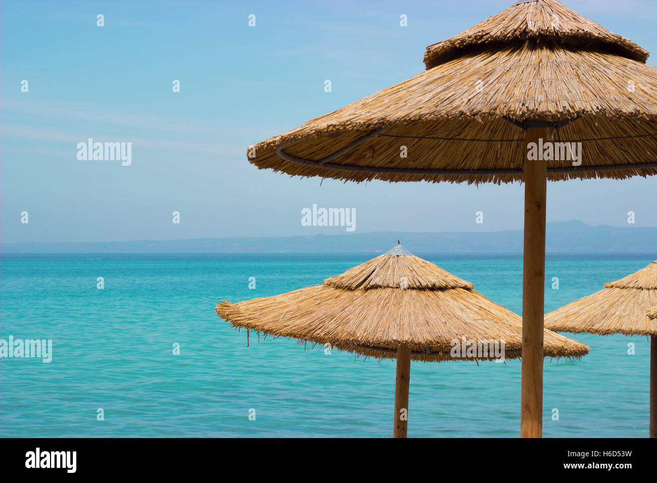 Ombrelloni di paglia sulla spiaggia Foto stock - Alamy