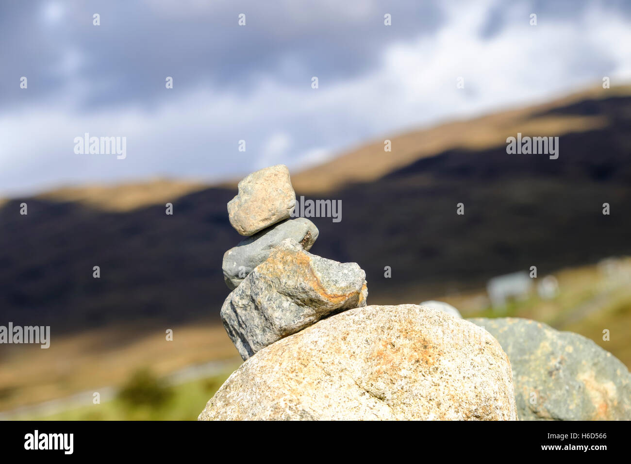 Il tumulo di attentamente pietre impilate contro uno sfondo morbido di Isola di Skye in Scozia paesaggio Foto Stock