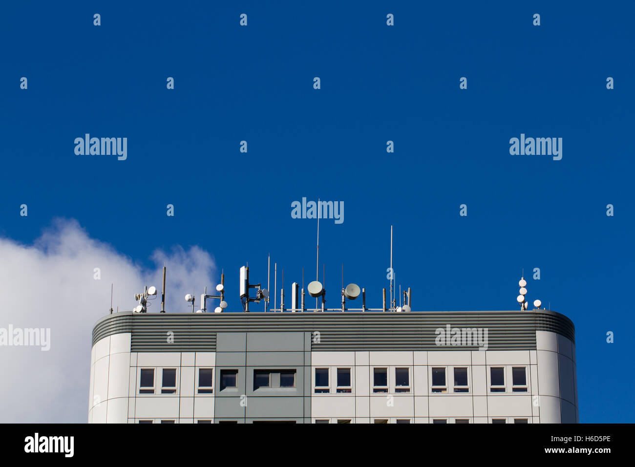 Il tetto di un grattacielo coperto con antenne, parabole satellitari, apparecchiature per le telecomunicazioni e antenne per telefonia mobile. Foto Stock