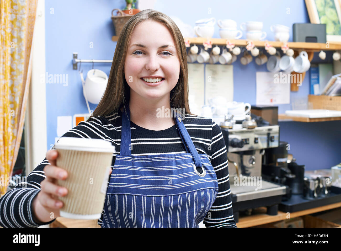 Cameriera In Cafe che serve il cliente con il caffè da asporto Foto Stock