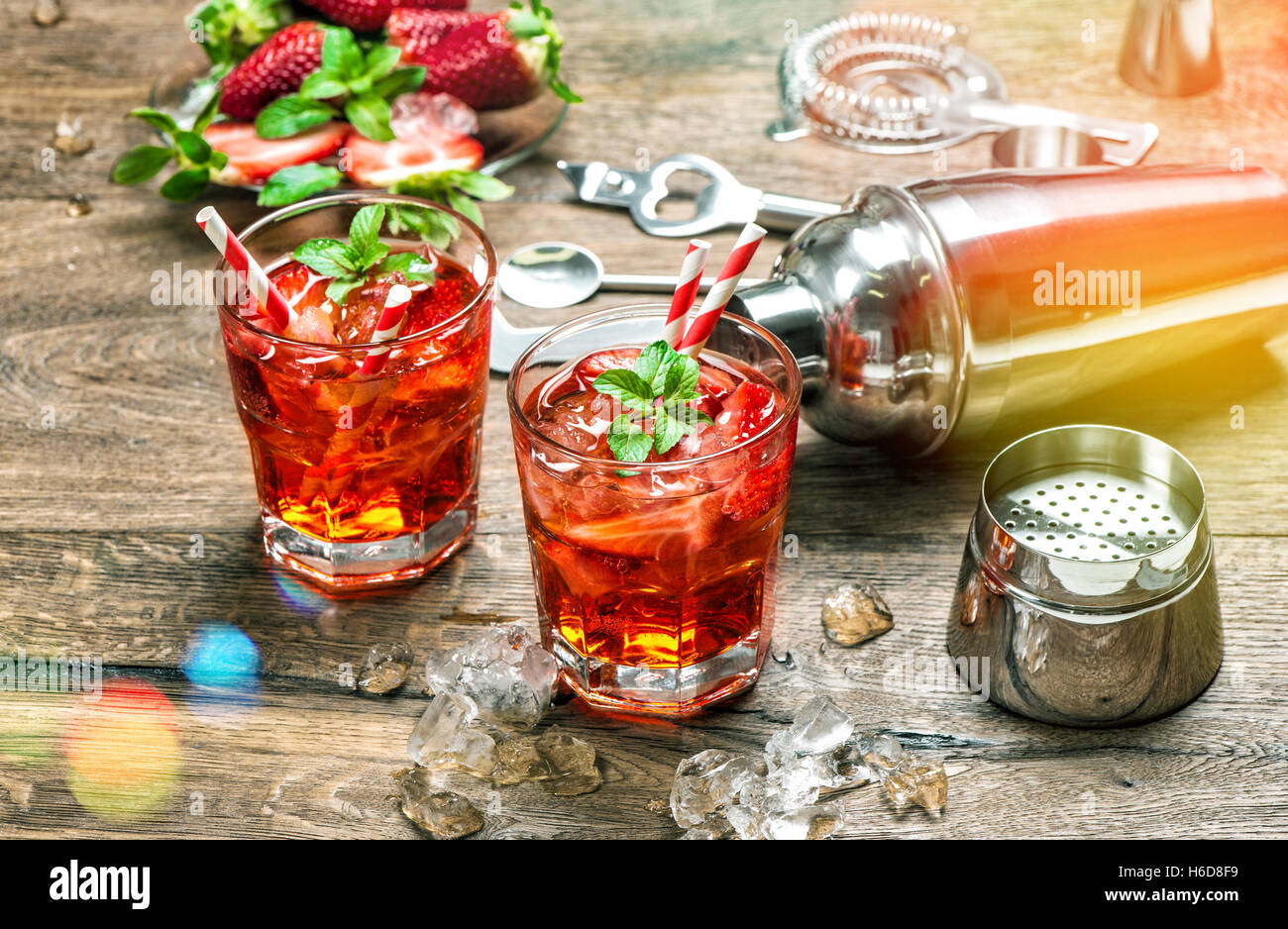 Red drink con ghiaccio. Aperitivo, mojito, caipirinha, succo. In stile vintage tonica immagine con perdite della luce Foto Stock