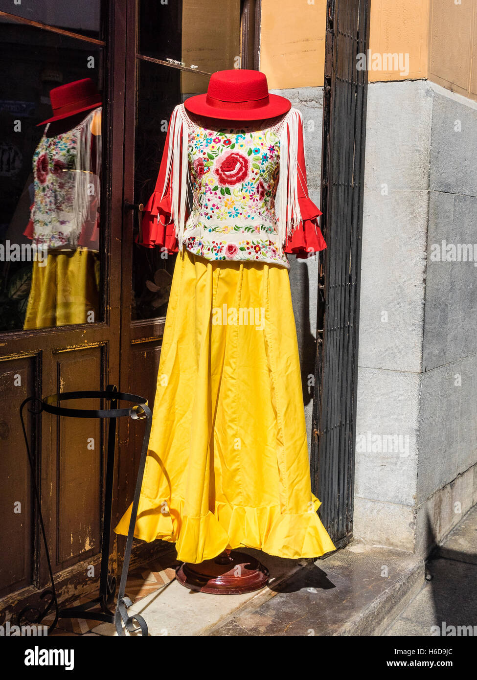 Manichino donna Siviglia, Spagna vestito per una fiesta con un Red Hat, luminoso giallo gonna e camicia ricamata. Foto Stock