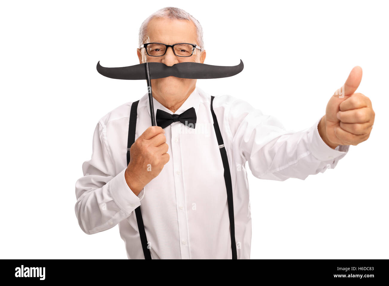Anziano gentiluomo in un bow tie e giarrettiere in posa con un grande baffi finti e dando un pollice in alto Foto Stock