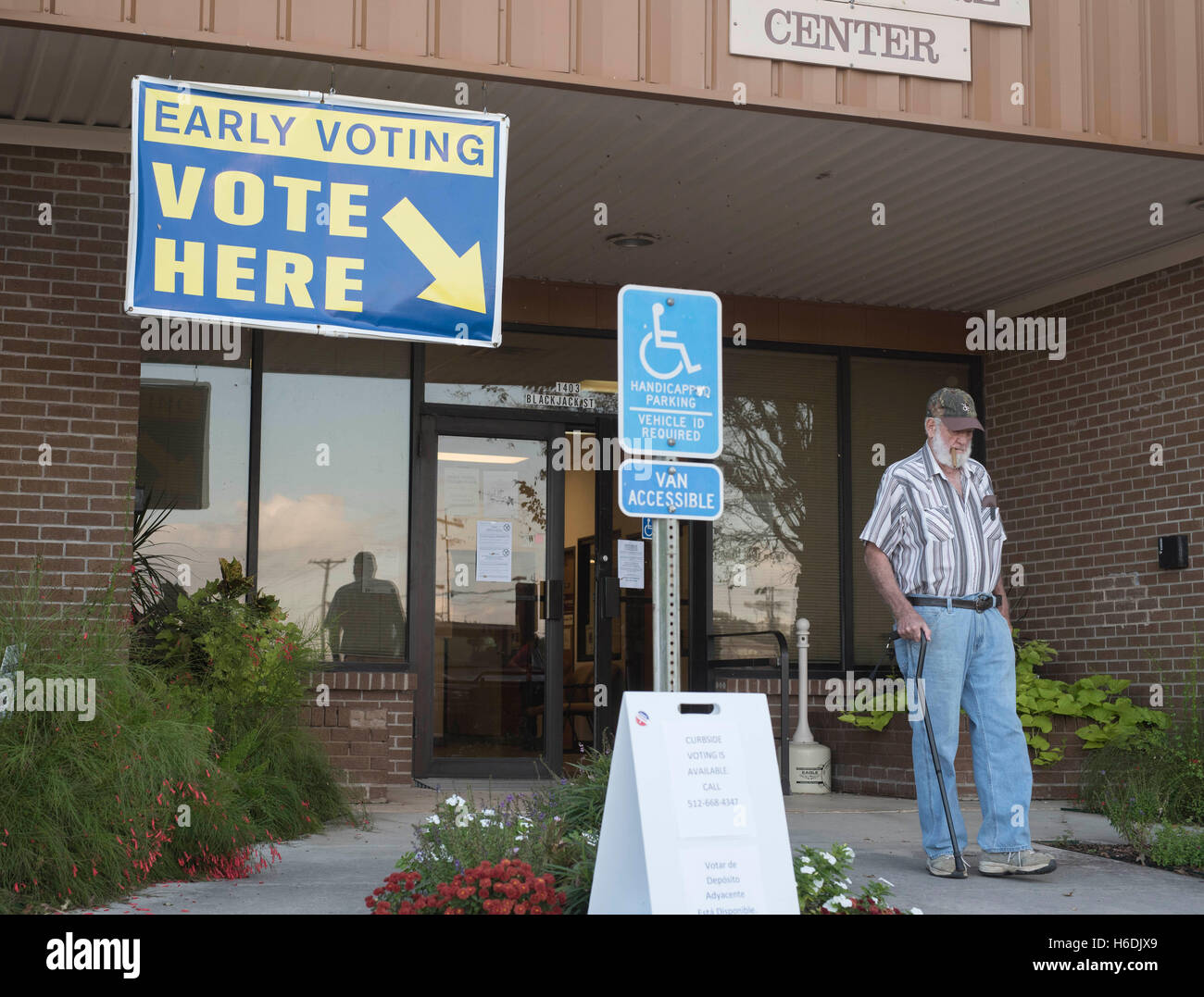 Elettore maschio in Lockhart,Texas, lascia il posto di polling come la prima settimana di voto anticipato continua in Texas. Foto Stock