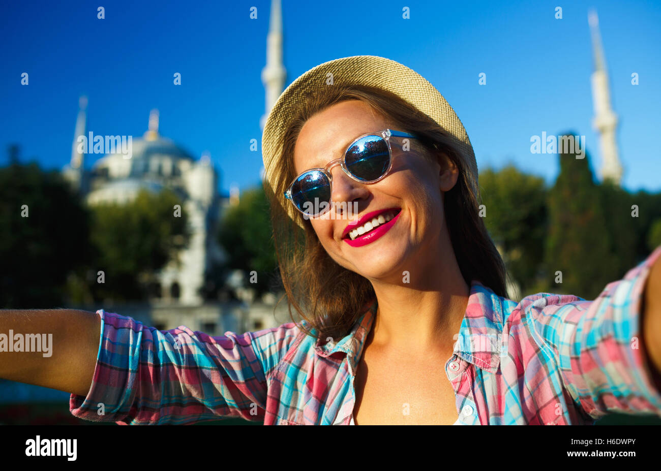 Ragazza in hat rendendo selfie dallo smartphone sullo sfondo della Moschea Blu, Istanbul. Turchia Foto Stock