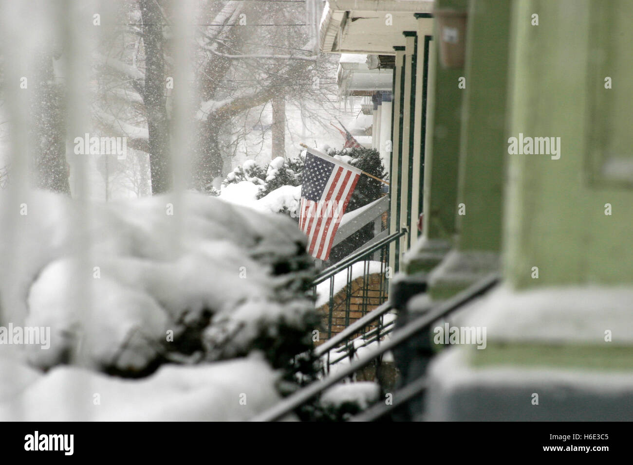 Cleveland, Ohio, Stati Uniti. Bandiera americana che sventolava davanti a casa in un quartiere in inverno. Foto Stock