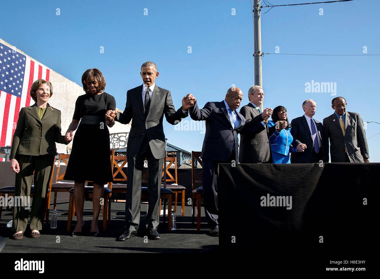 Ex First Lady Laura Bush e la First Lady Michelle Obama, Presidente Barack Obama, Georgia Congressman John Lewis e l ex Presidente George W Bush tenere mani e pregare durante un evento per la commemorazione del cinquantesimo anniversario della Bloody Sunday e i diritti civili marce a Edmund Pettus Bridge Marzo 7, 2015 in Selma, Alabama. Foto Stock