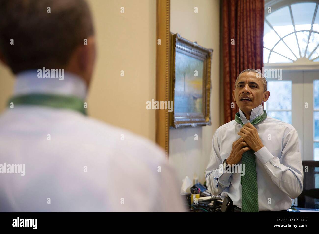 Stati Uniti Il presidente Barack Obama mette su una cravatta verde per San Patrizio giorno nella Casa Bianca esterna Ufficio Ovale Marzo 17, 2015 a Washington, DC. Foto Stock