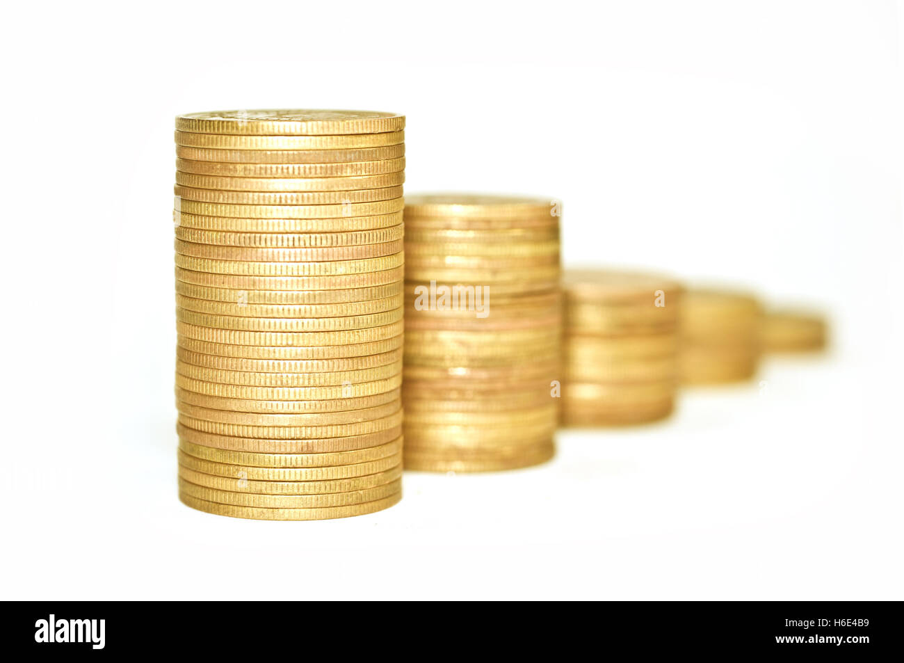 Concetti economici. Le monete d'oro su sfondo bianco. Monete impilate una sull'altra. Macro. Focus sul primo mucchio di monete. Foto Stock
